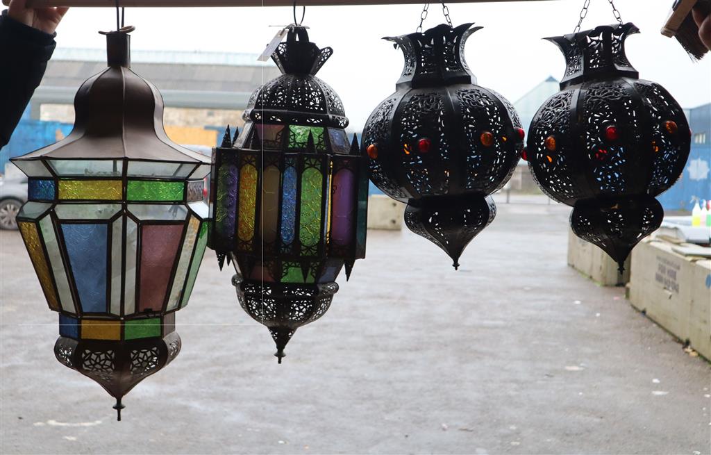 Two Moroccan copper and stained glass octagonal hanging lanterns and a pair of pierced bronzed metal lanterns, largest 66cm high